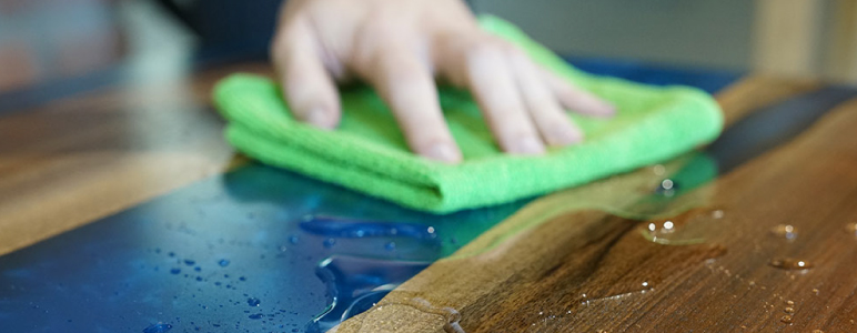 Cleaning an epoxy river table with alcohol.